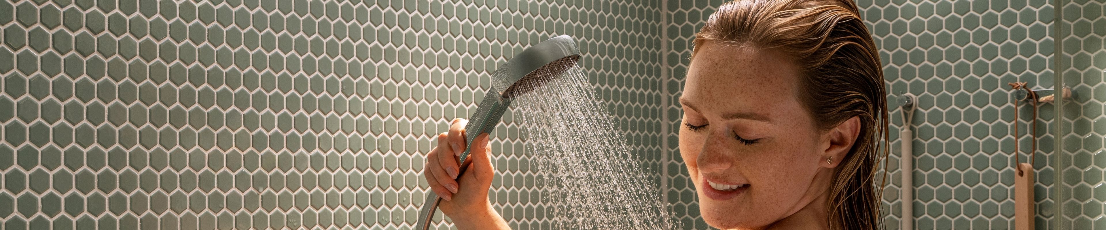 Woman is visibly impressed as she showers with the Activera Q shower pipe.