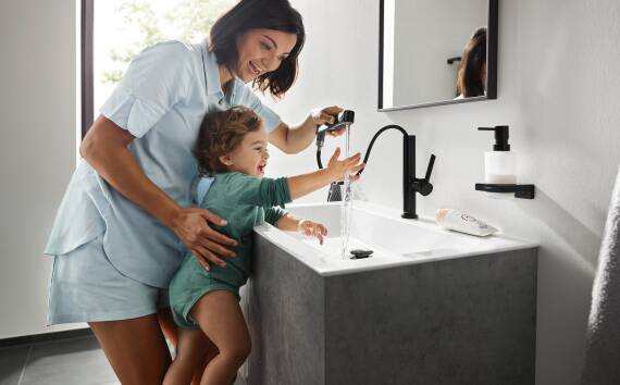 Mother and child play around with the Finoris lavatory faucet.
