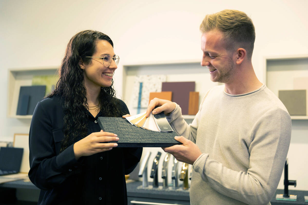 Zwei Personen vergleichen Fliese mit einer Farbpalette