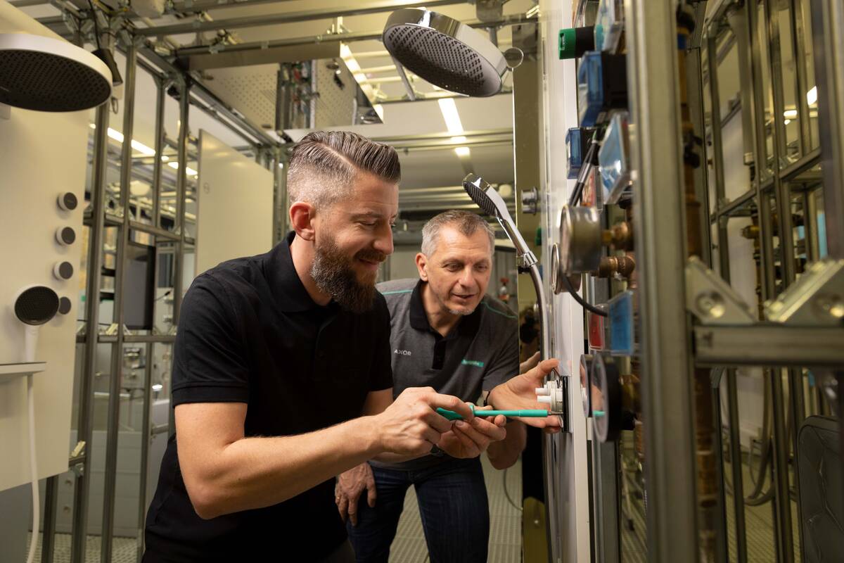 Seminarteilnehmer und Hansgrohe TSC Trainer installieren gemeinsam ein Thermostat