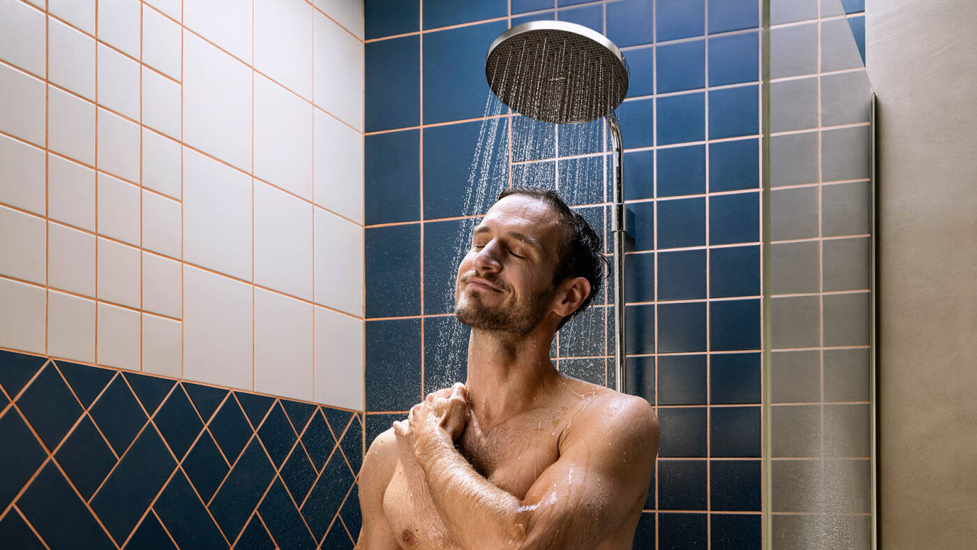 Mężczyzna kąpie się pod głowicą prysznicową hansgrohe Activera.