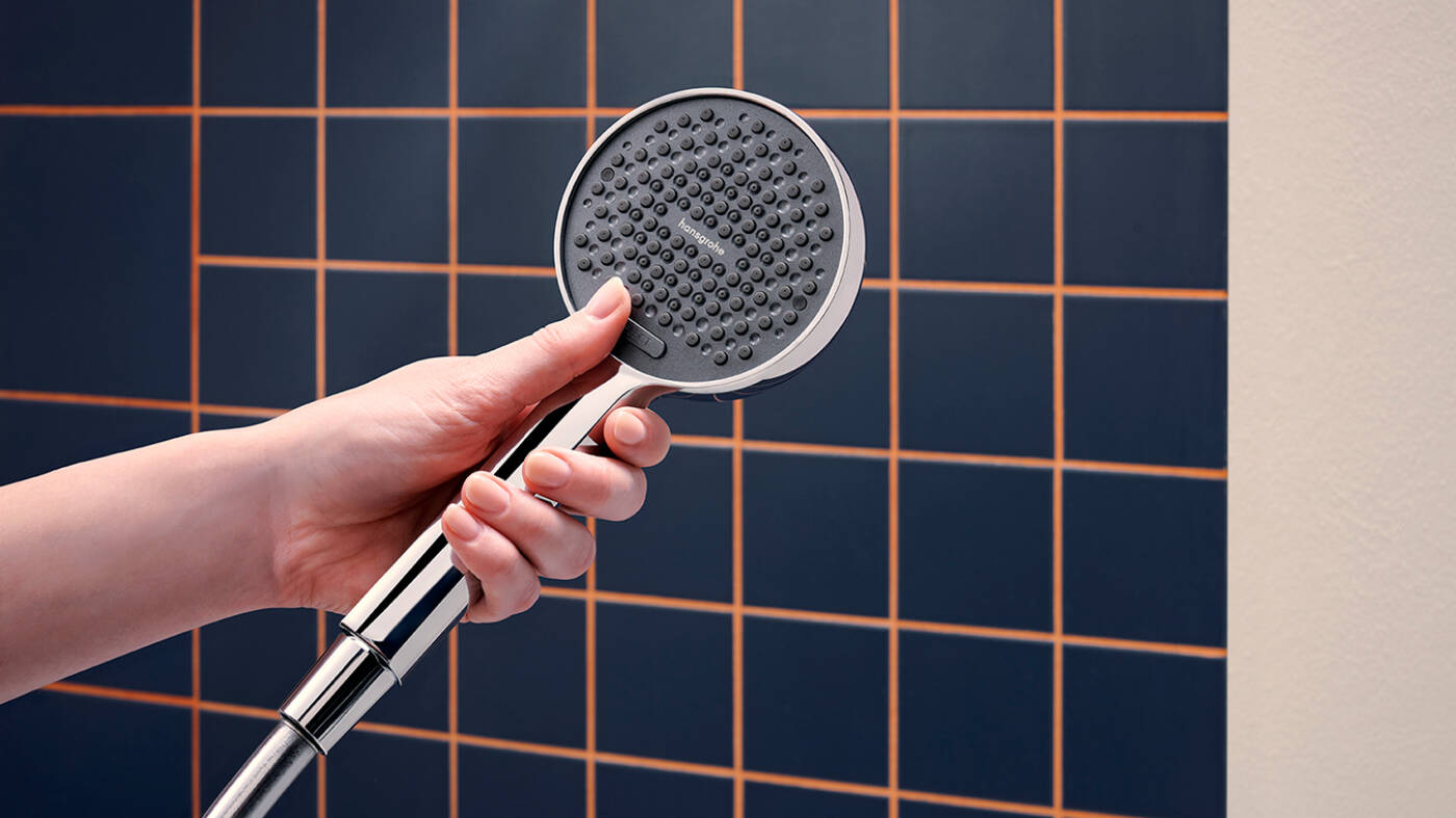 Woman’s hand rubbing limescale off Raindance Alive overhead shower.