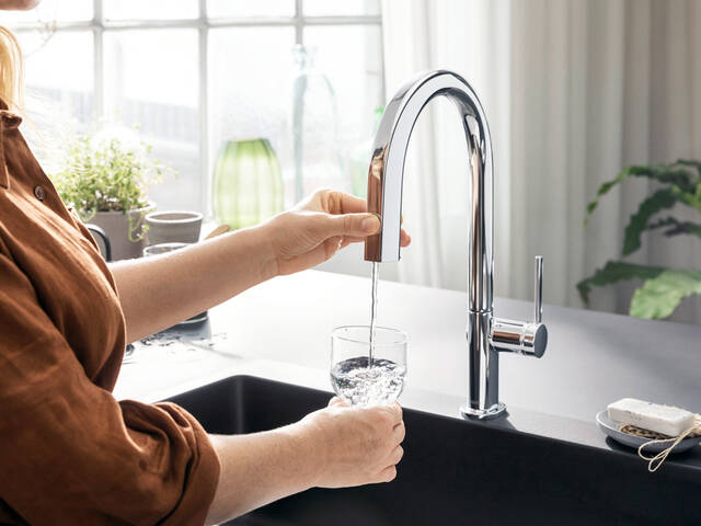 Woman filling a glass of water at the Aqittura M91.