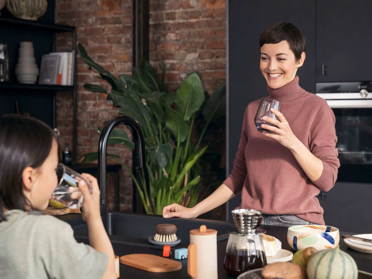 Žena uzima vodu iz miješalice Aqittura M91 SodaBase.