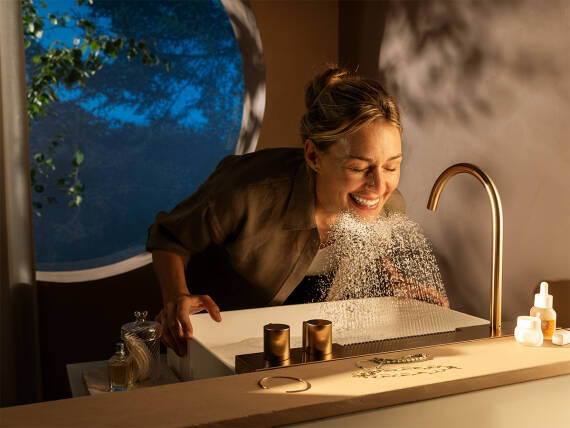 Mujer sonriente lavándose el rostro sobre la AquaUnit Avalegra.