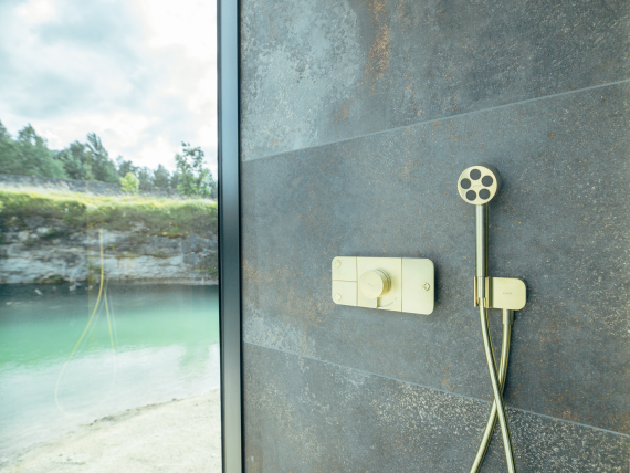 AXOR One thermostat with hand shower in Brushed Brass. AXOR One thermostat with hand shower in Brushed Brass.