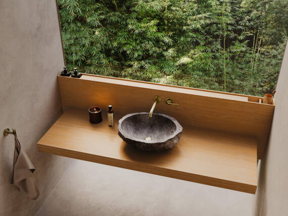 Mezclador monomando de lavabo AXOR Archivio con lavabo de piedra moldeada.