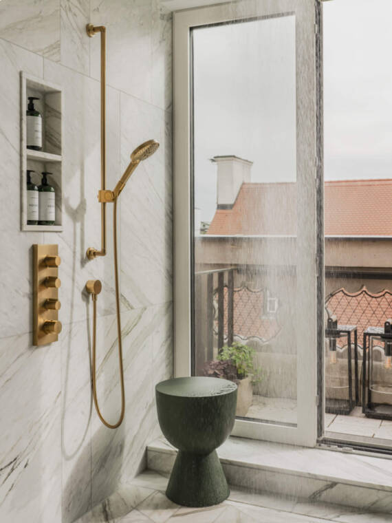 Illustration of a luxurious bathroom with marble tiles and AXOR ShowerSolutions hand shower in Brushed Gold Optic. Illustration of a luxurious bathroom with marble tiles and AXOR ShowerSolutions hand shower in Brushed Gold Optic.
