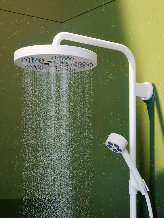 Close-up of an AXOR One hand shower in Matt White in a bathroom with green tiles. Close-up of an AXOR One hand shower in Matt White in a bathroom with green tiles.