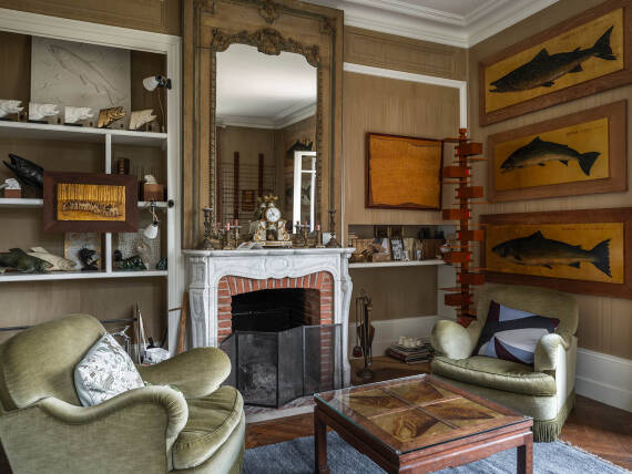 Il salotto con camino aperto e opere d'arte del proprietario
