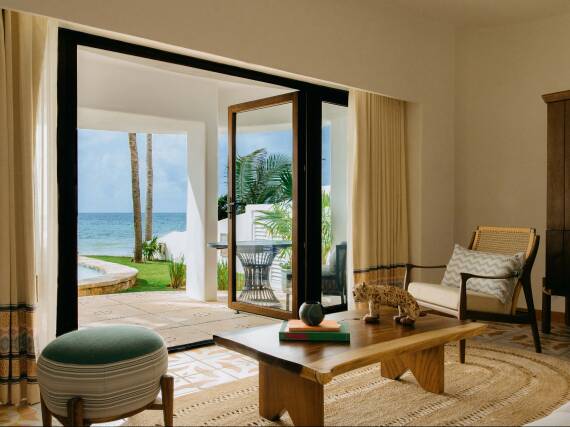 Luminosa zona de estar en el Belmond Maroma con vistas al mar y al jardín.