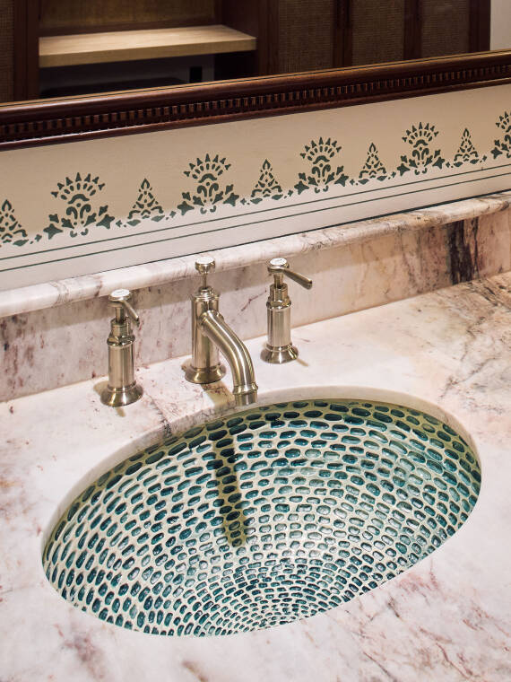 El lavabo con motivos en color turquesa se complementa con el mezclador de tres vías AXOR Montreux en níquel cepillado