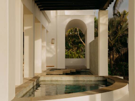 Vista de los arcos blancos arquitectónicos y una piscina del hotel Maroma