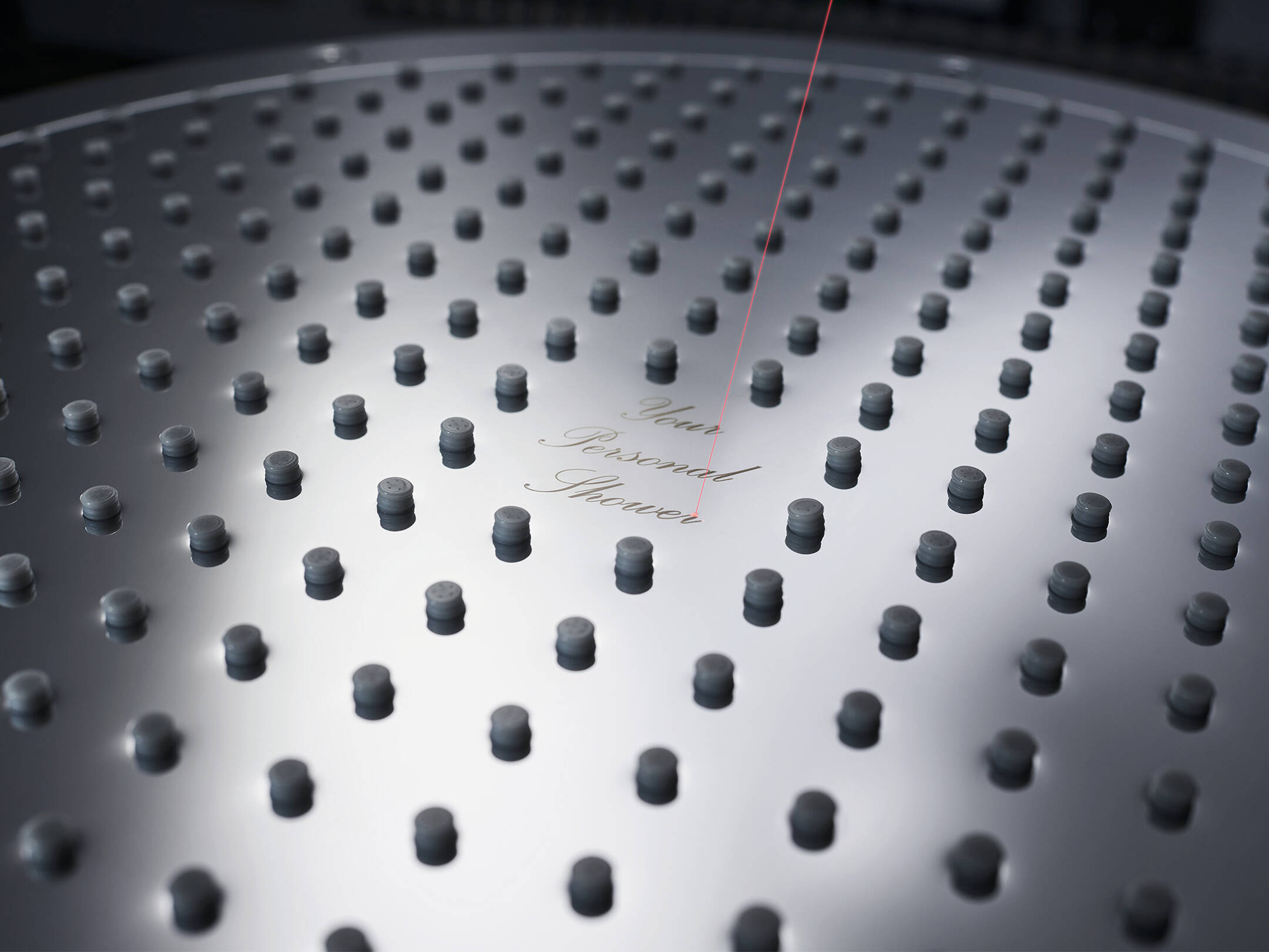 Ein individuelles Logo während des Laserprozesses auf einer AXOR Dusche.  Ein individuelles Logo während des Laserprozesses auf einer AXOR Dusche.