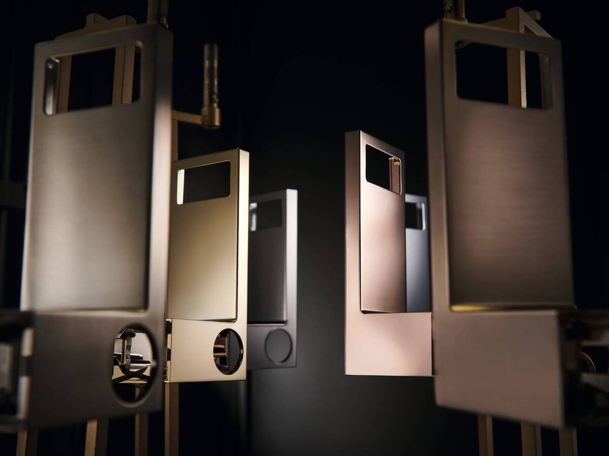 Několik komponent baterií AXOR s různými PVD úpravami.