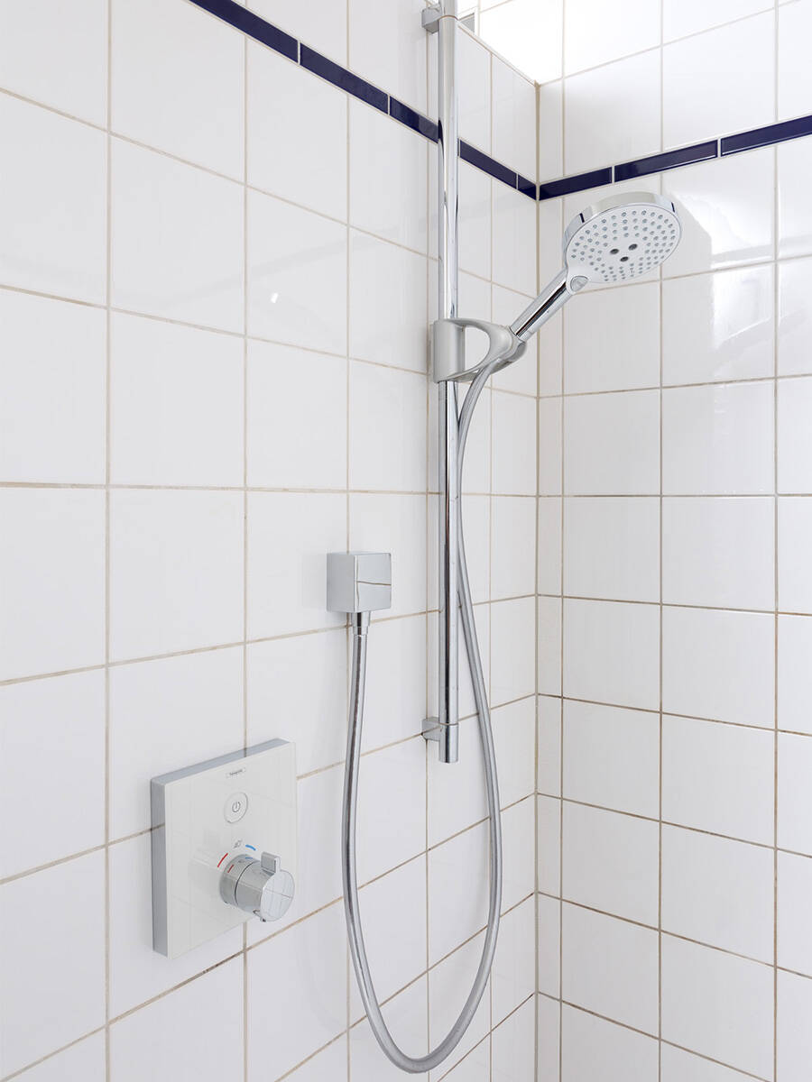 Imagen de una ducha de lluvia montada en la pared en un baño moderno.