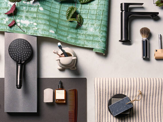 Moodboard mit schwarzem Duschkopf und Waschtischarmatur und weiteren Elementen.