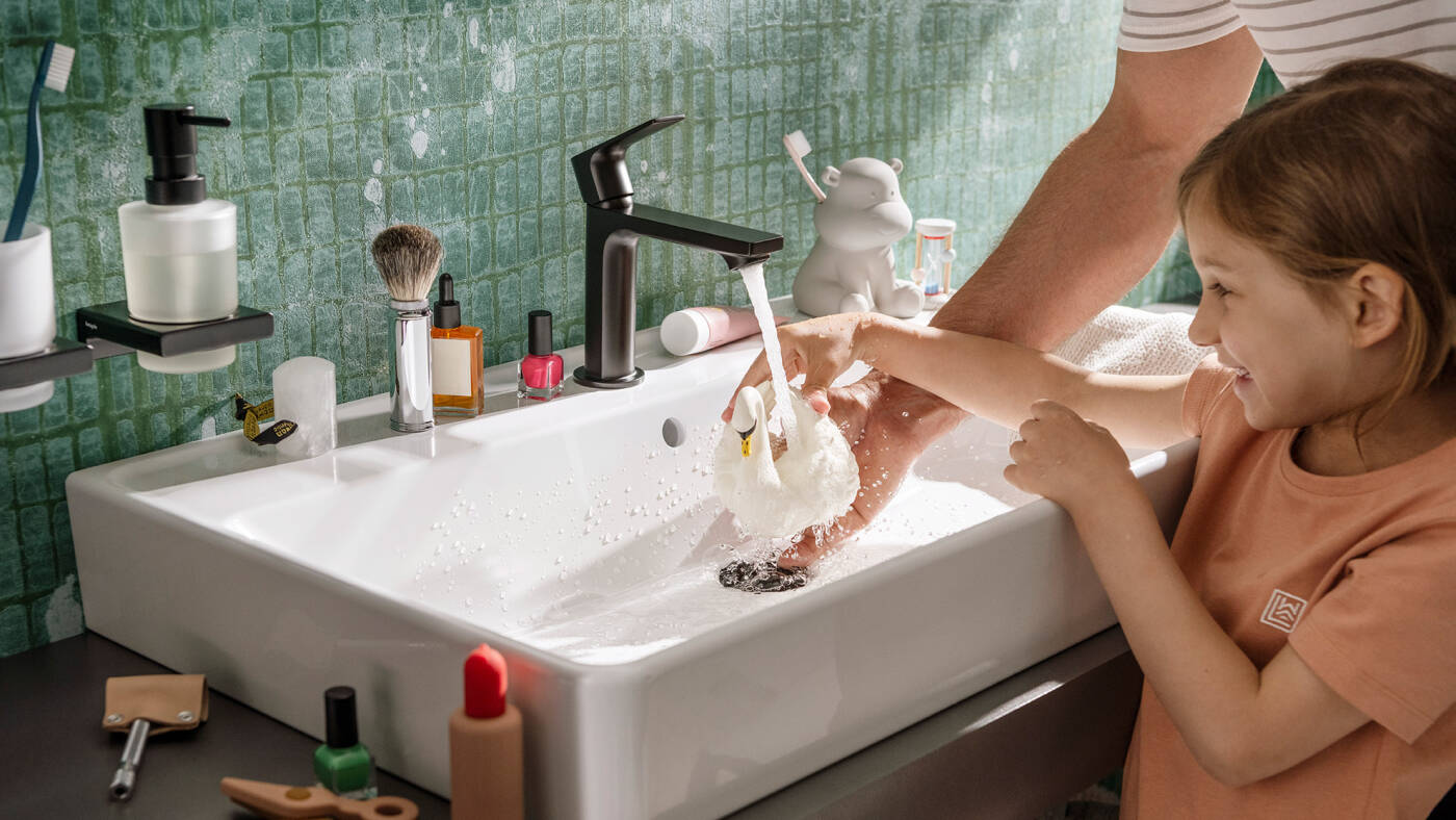 Waschbecken mit mattschwarzer, sparsamer hansgrohe Armatur.