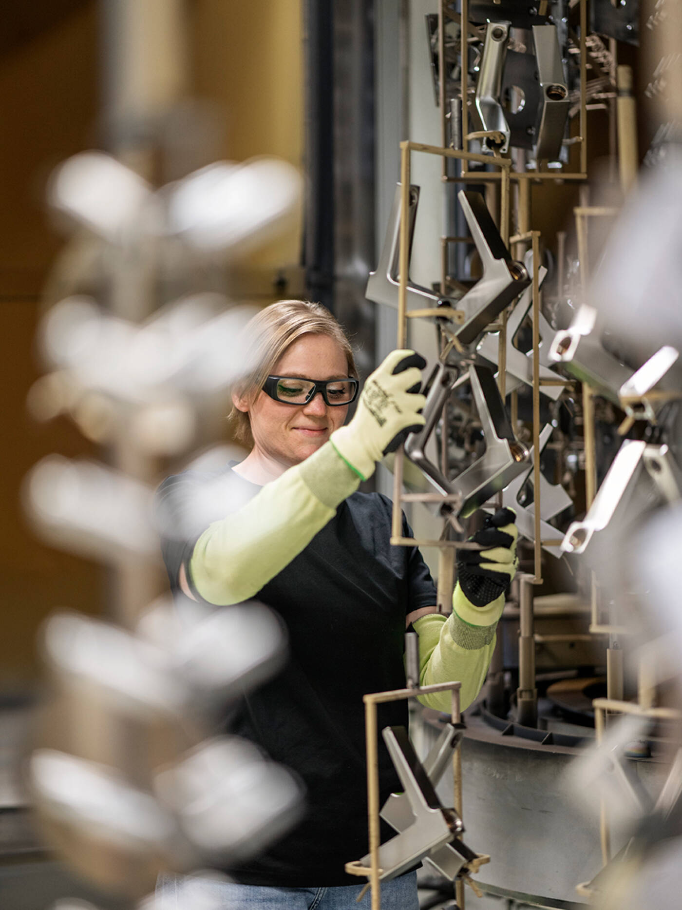 Hansgrohe Mitarbeiterin setzt Armaturen in PVD-Kammer.