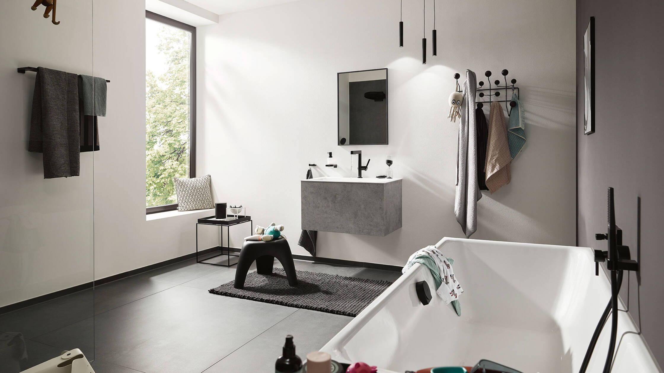Puristisk badeværelse med kantede former og matsorte detaljer.
