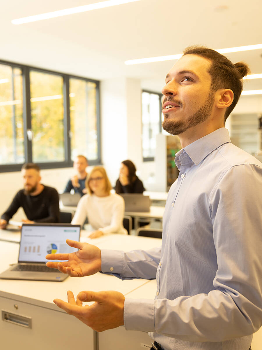 Seminar leader stands in front of a class of seminar professionals.
