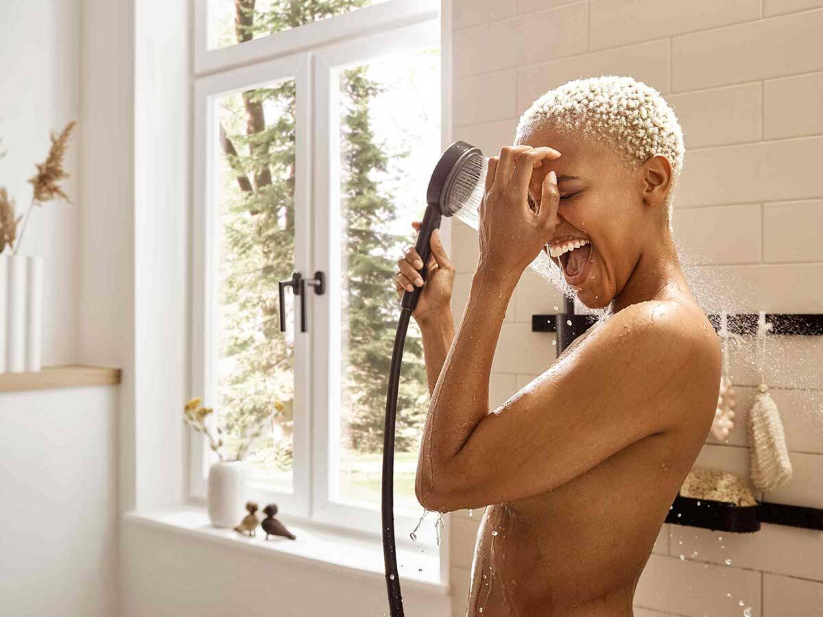 Frau duscht mit Handbrause Pulsify.	