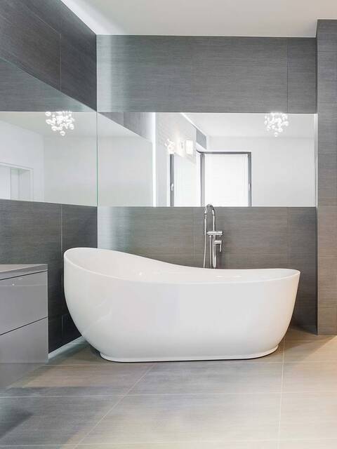 Salle de bains grise et blanche avec miroir sur le pourtour