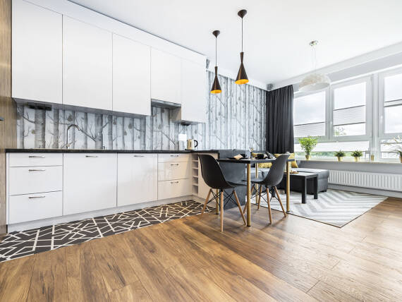 Dunkler Boden aus Holz in Kombination mit Fliesen.	