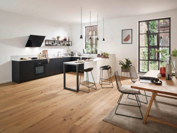 Küche in U-Form mit Herd und Dunstabzugshaube.	