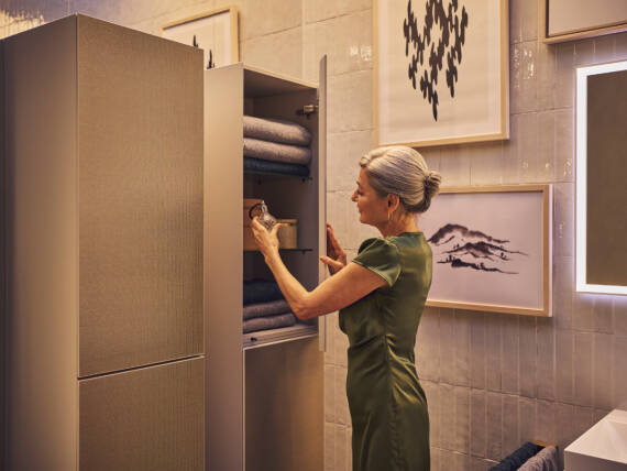 Woman at the bathroom cabinet made of sustainable material.