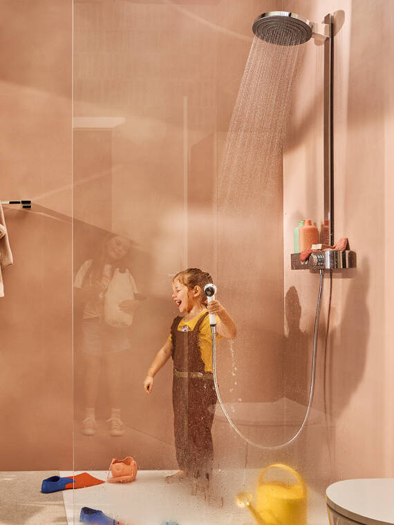 Dusche mit Glas-Trennwand und Kind im Bad.