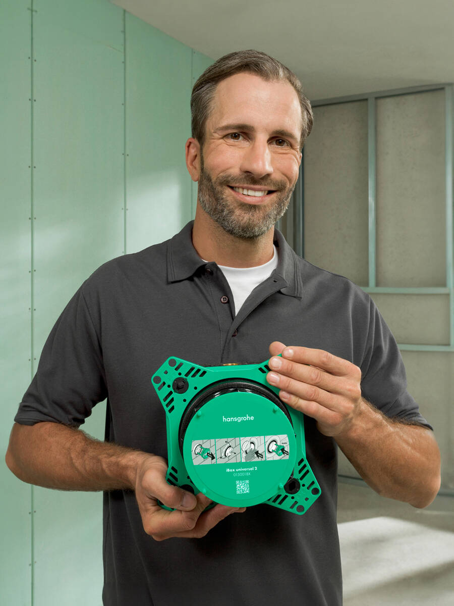 Netter Sanitärprofi hält eine iBox universal 2 in Händen.