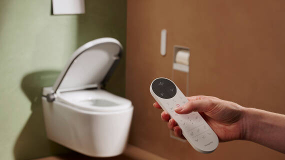 Hand operates LavaPura Element remote control.