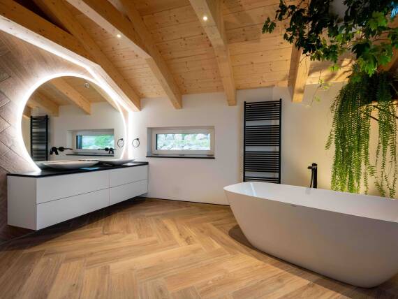 Salle de bains moderne avec baignoire en îlot et soupente en bois.