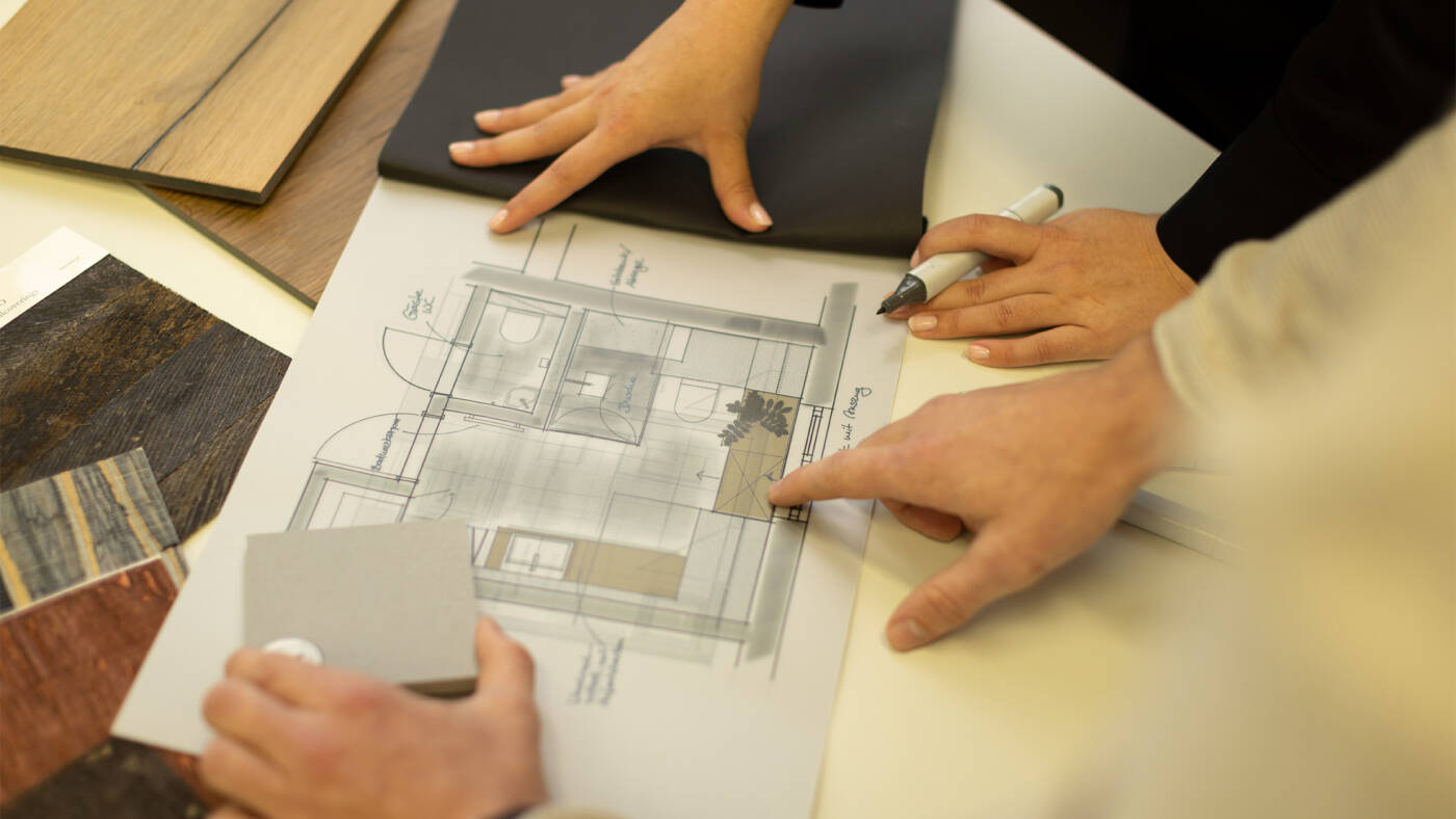 Bathroom floor plan with planners’ hands. 