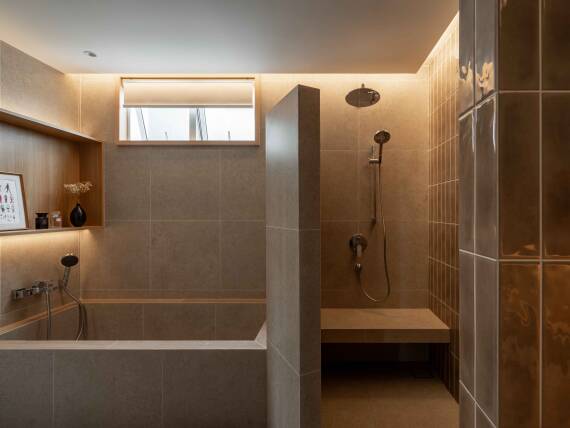 Salle de bains moderne avec espace de douche ouvert et baignoire intégrée.