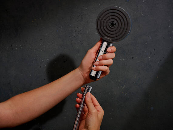 Suihkuletku irrotetaan Pulsify-käsisuihkusta.