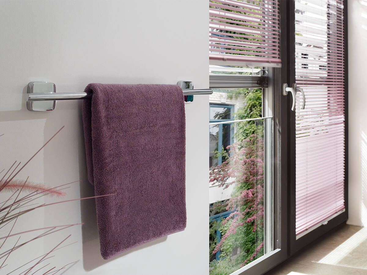 Sichtbeton im Bad mit Handtuchhalter aus Chrom.