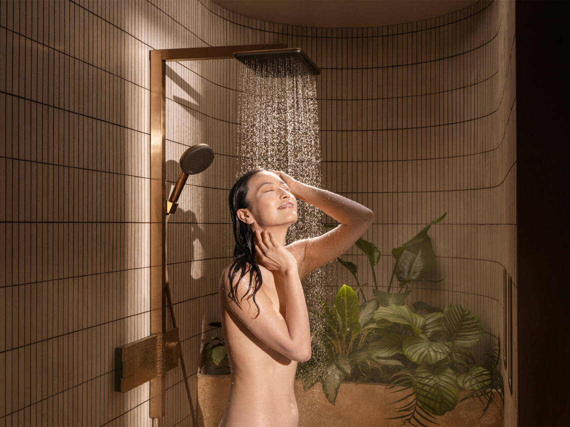 Frau unter Regendusche im Japandi-Bad.