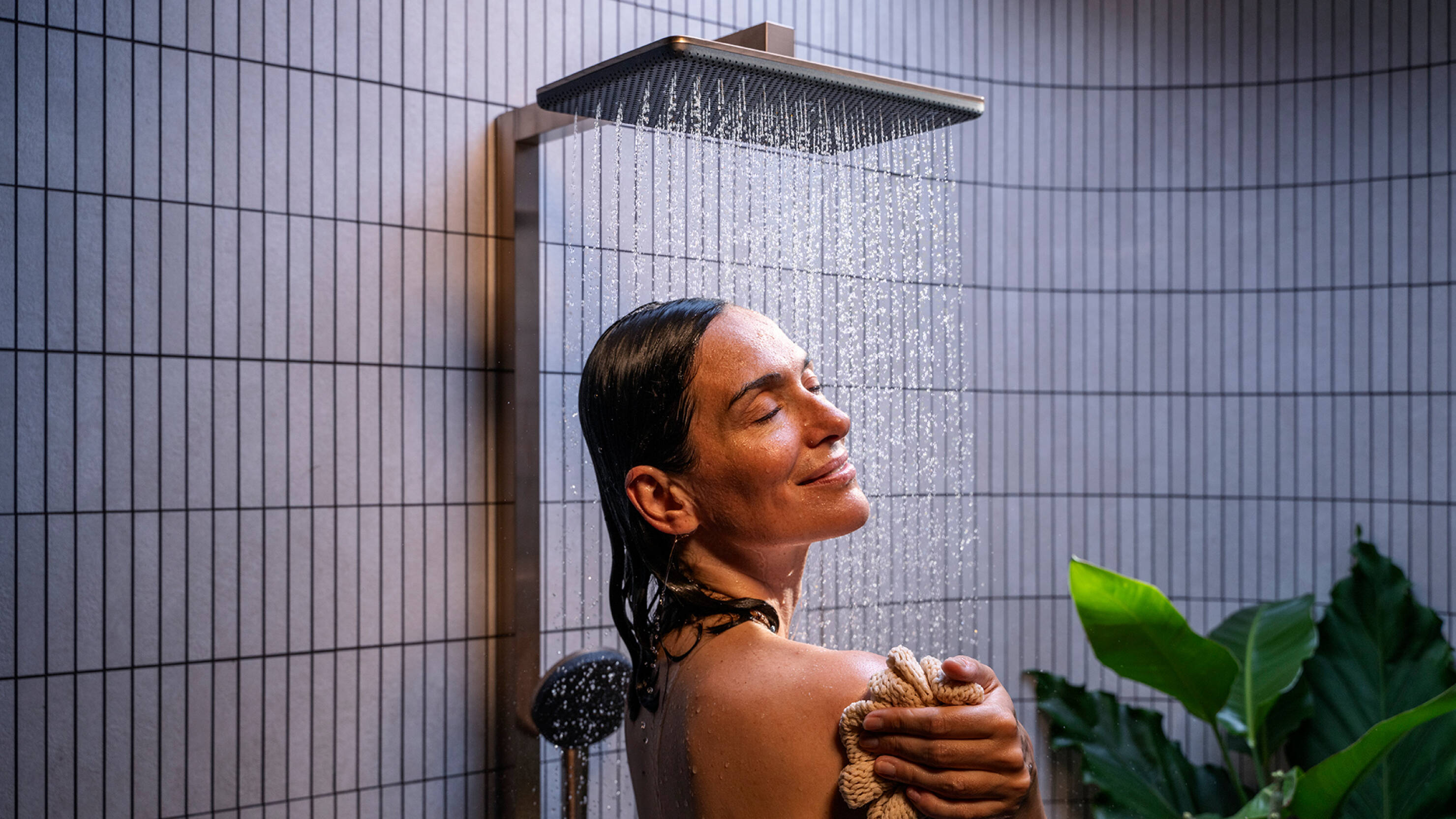 Frau genießt Dusche mit AirPower-Technologie.