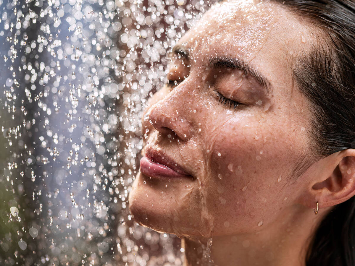Emotionele douchebeeld met vrouw onder hansgrohe douche.