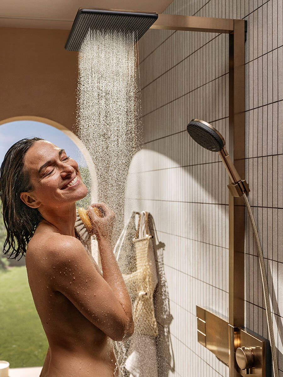Frau duscht begeistert mit Raindance Alive Duschsystem.