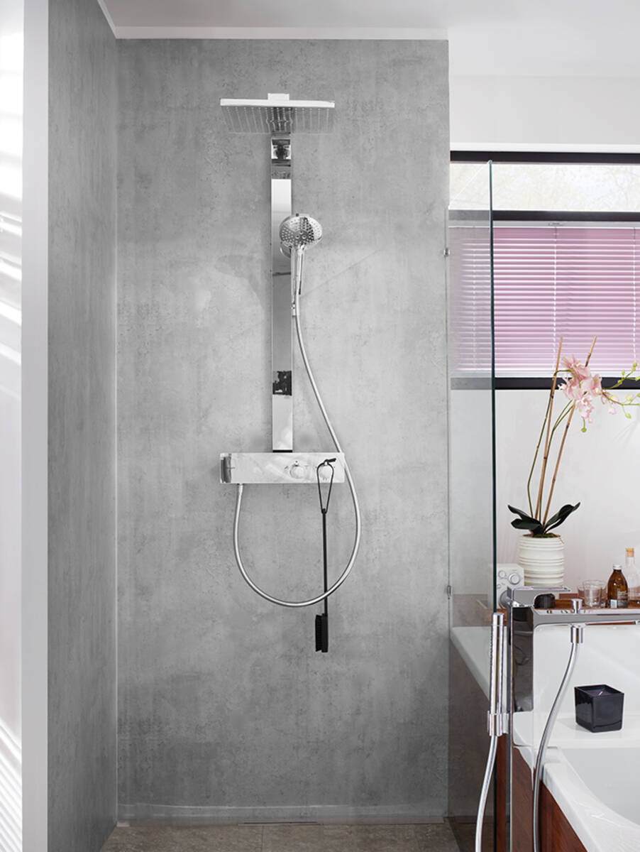 Sichtbeton im Bad mit Duschsystem aus Chrom.