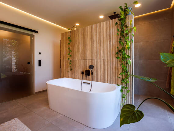 Salle de bains moderne avec baignoire en îlot et mur à panneaux de bois.