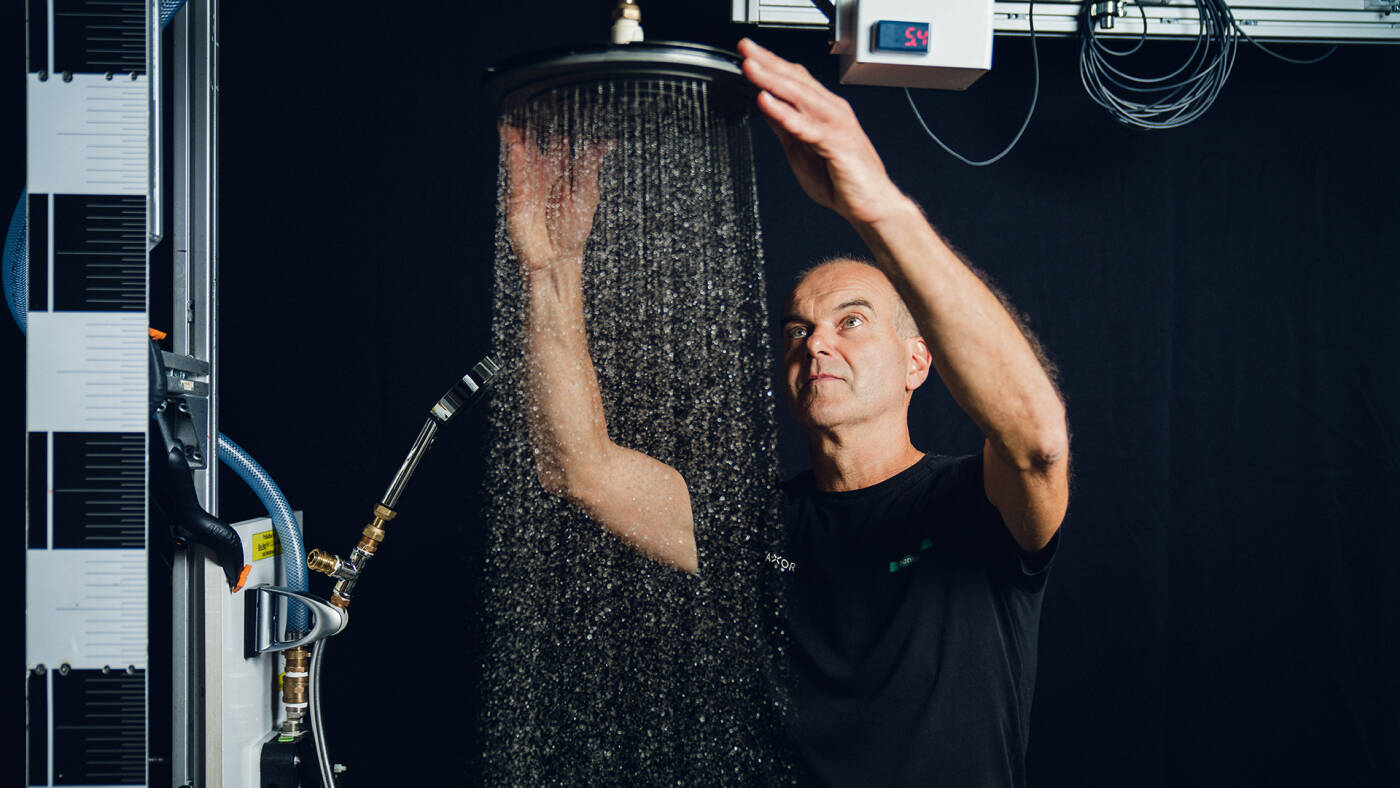 Ekspert w laboratorium strumieni hansgrohe z głowicą prysznicową.