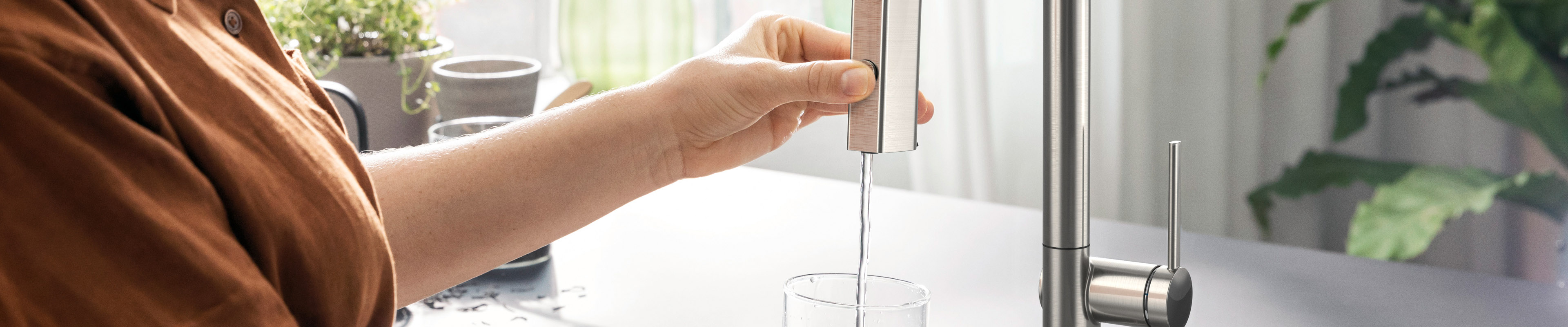 Aqittura M91 at the sink, woman drawing water.