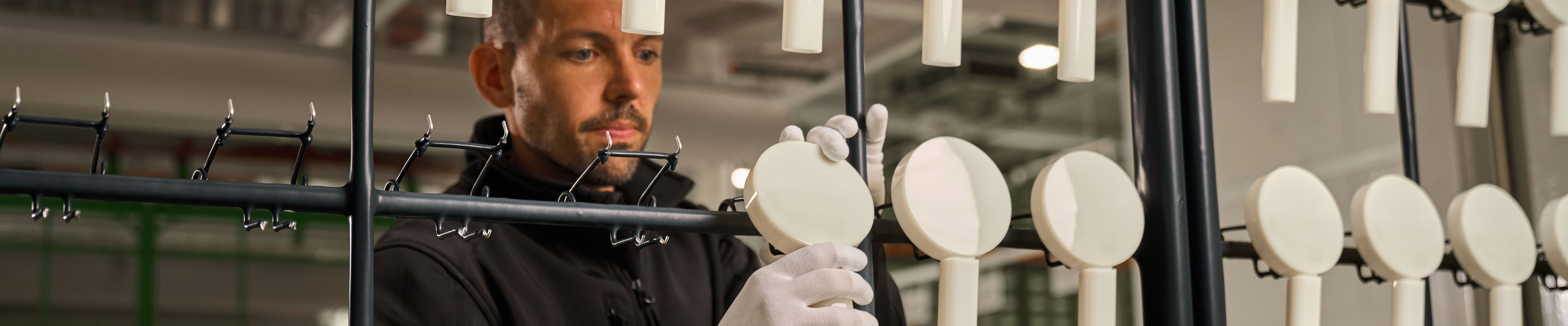 Mann prüft Brausen in der Hansgrohe Fertigung.