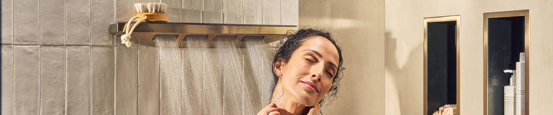 Vrouw geniet van hansgrohe straalsoort van haar zijdouche.