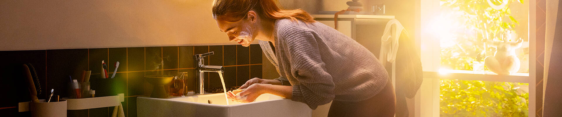 Woman washes her face with a hansgrohe Zesis S tap.