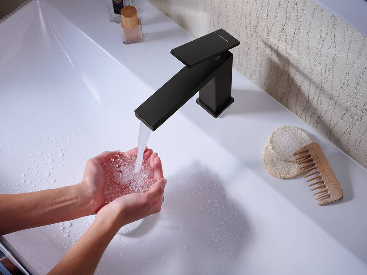 Mitigeur noir mat Metropol de hansgrohe sur un lavabo noir.